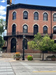 A bustling Main Street in downtown Longmont, lined with historic buildings, local shops, and vibrant street life